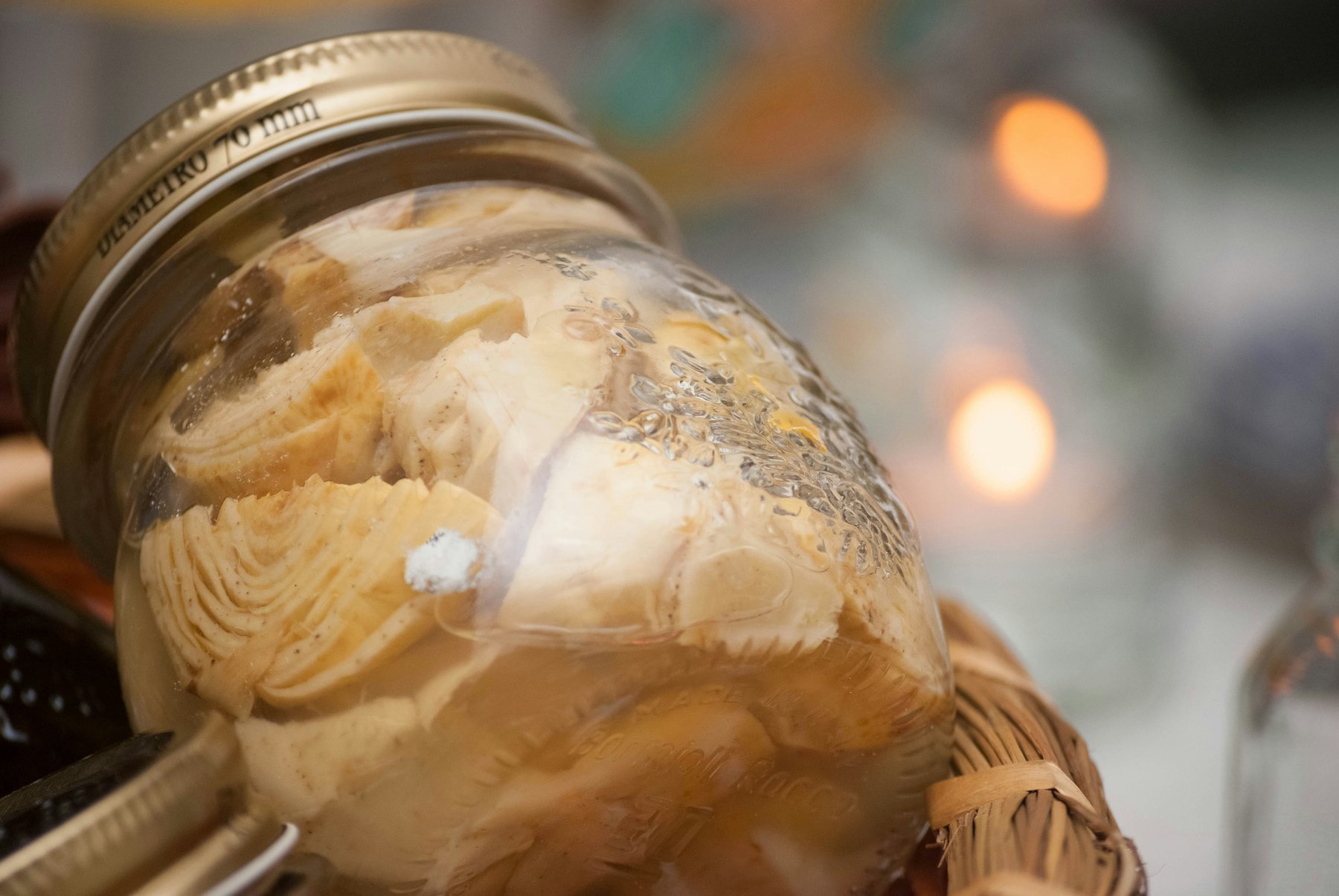 A clear glass jar of fermented vegetables on a table