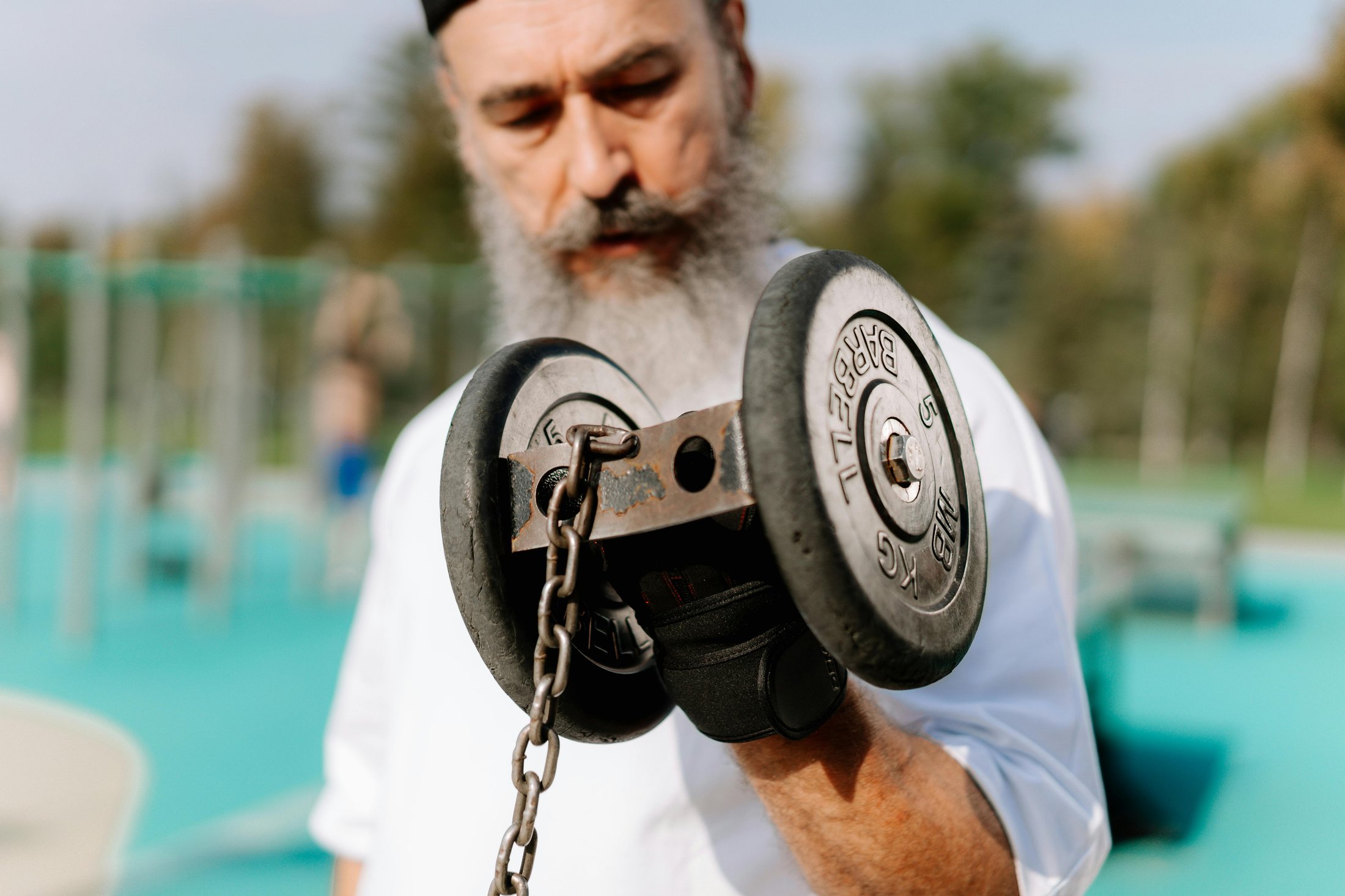 Older man lifting a dumbbell outdoors