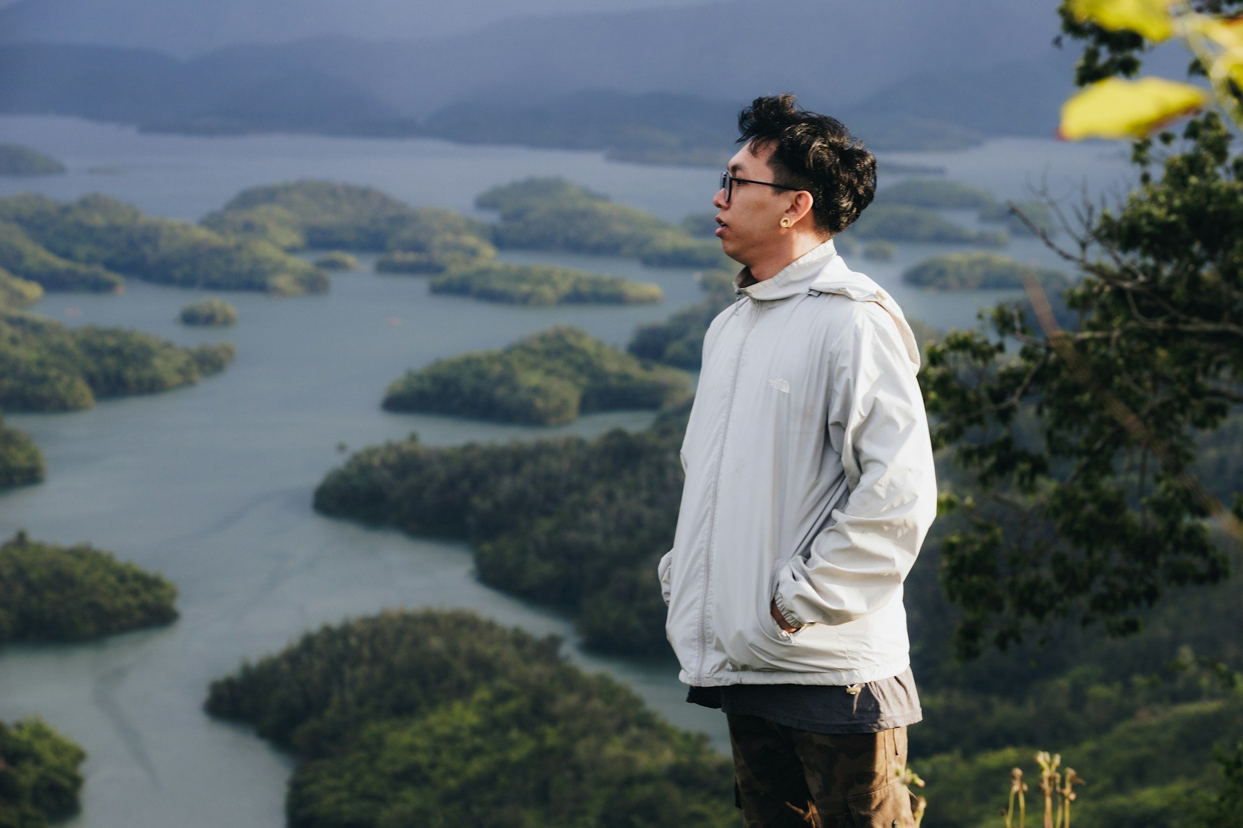 Person sitting quietly above a mountain lake
