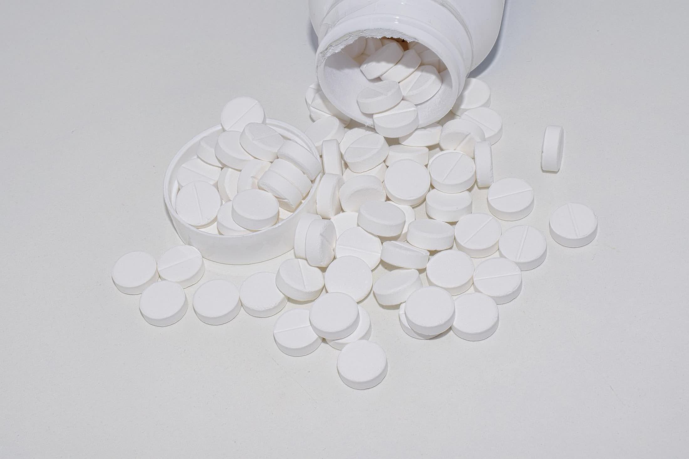White magnesium supplement tablets spilled from a bottle