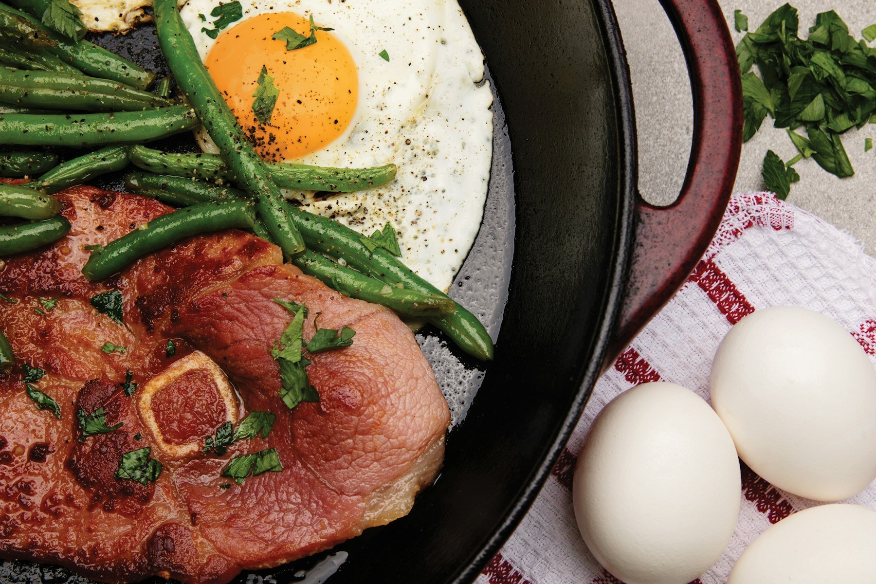 A protein-rich meal with beans, eggs, and vegetables in a pan