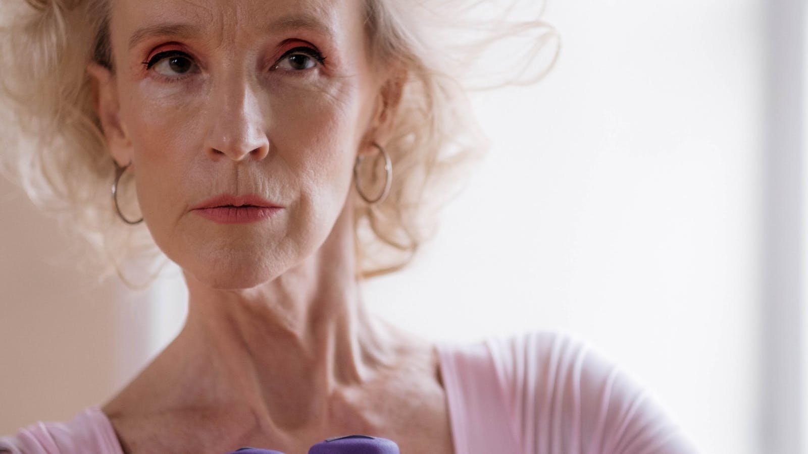 Older woman strength training with dumbbells indoors