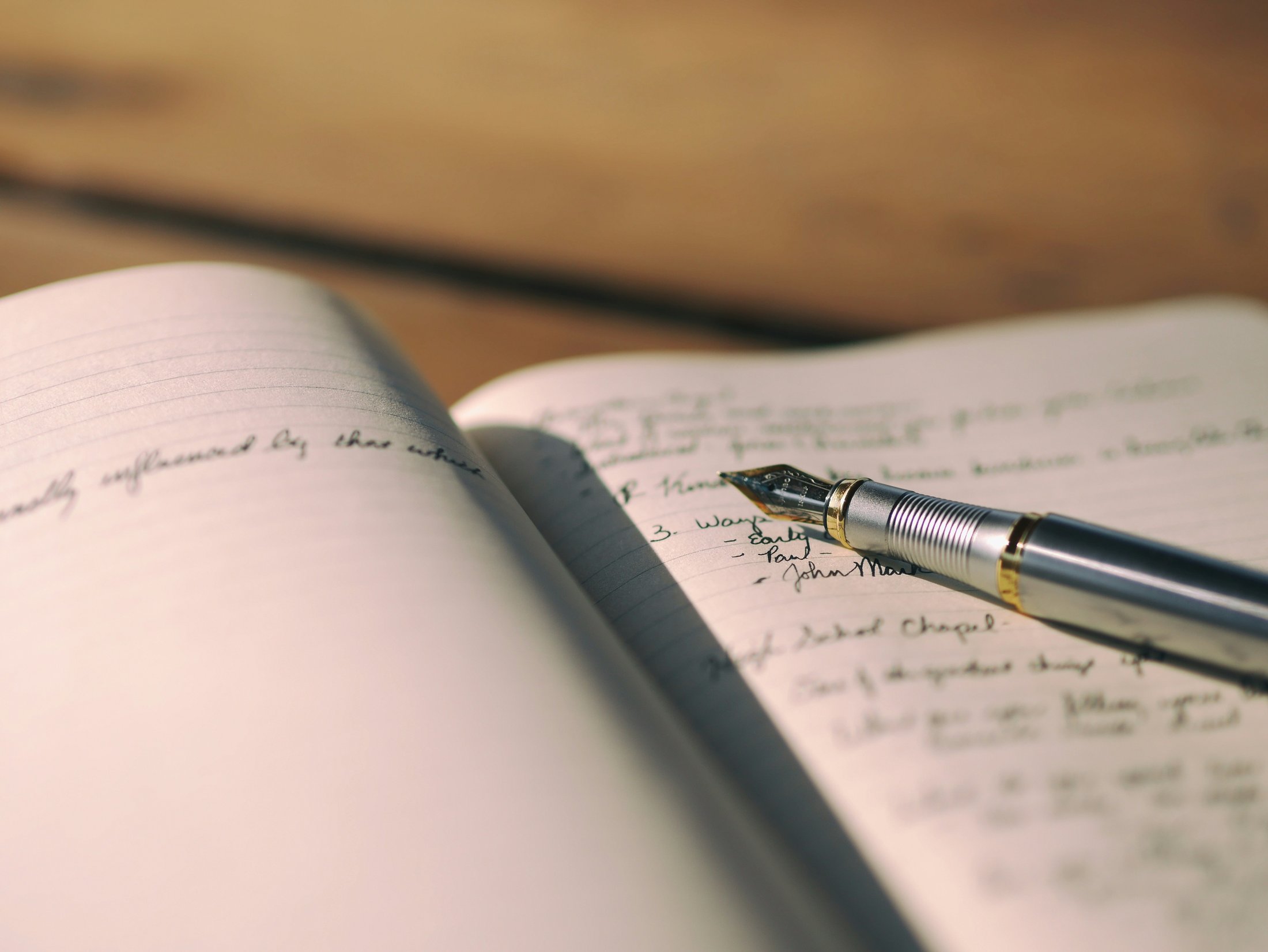 Close-up of a pen resting on lined notebook paper