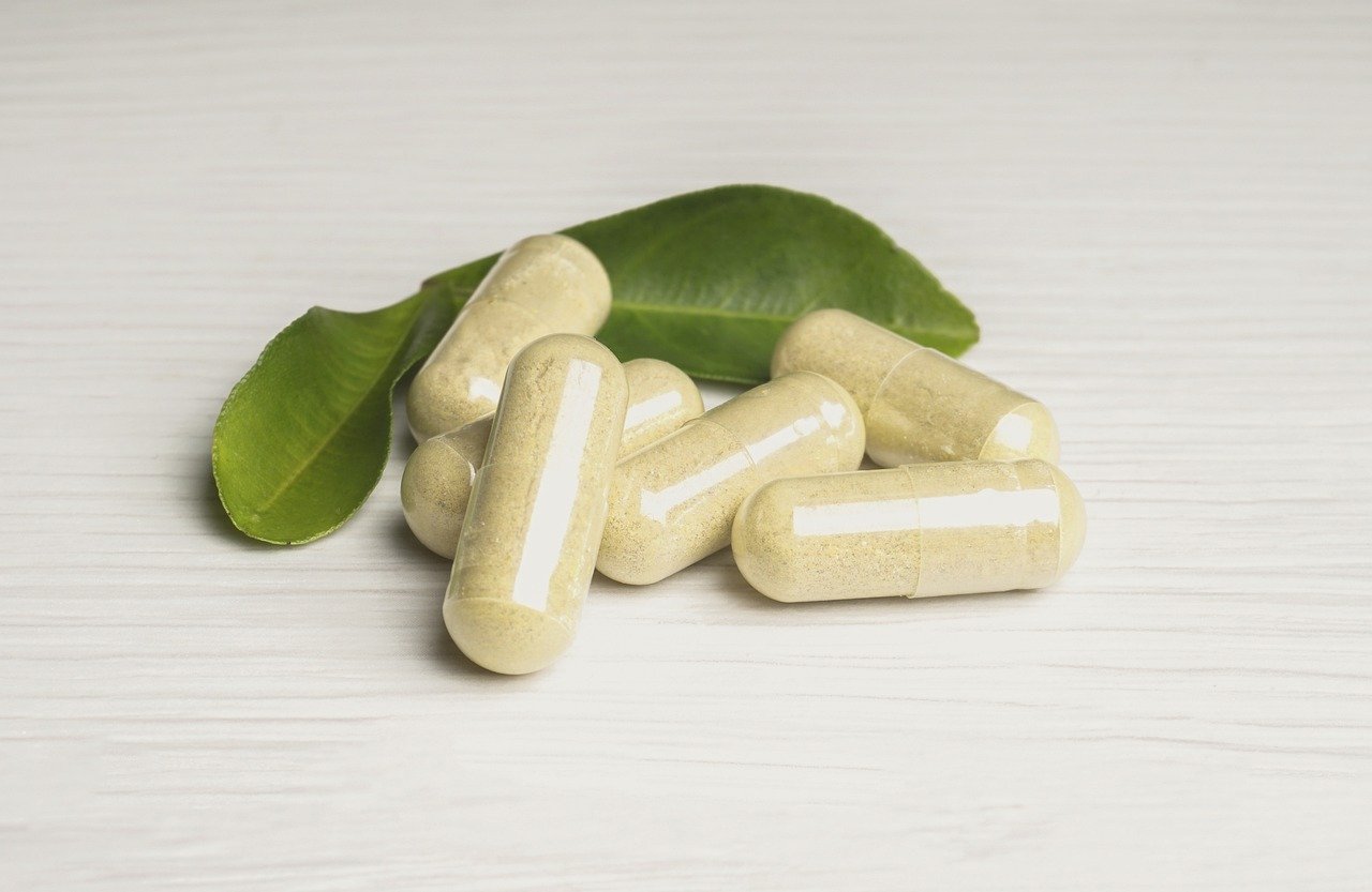 Vitamin capsules and tablets arranged on a light surface