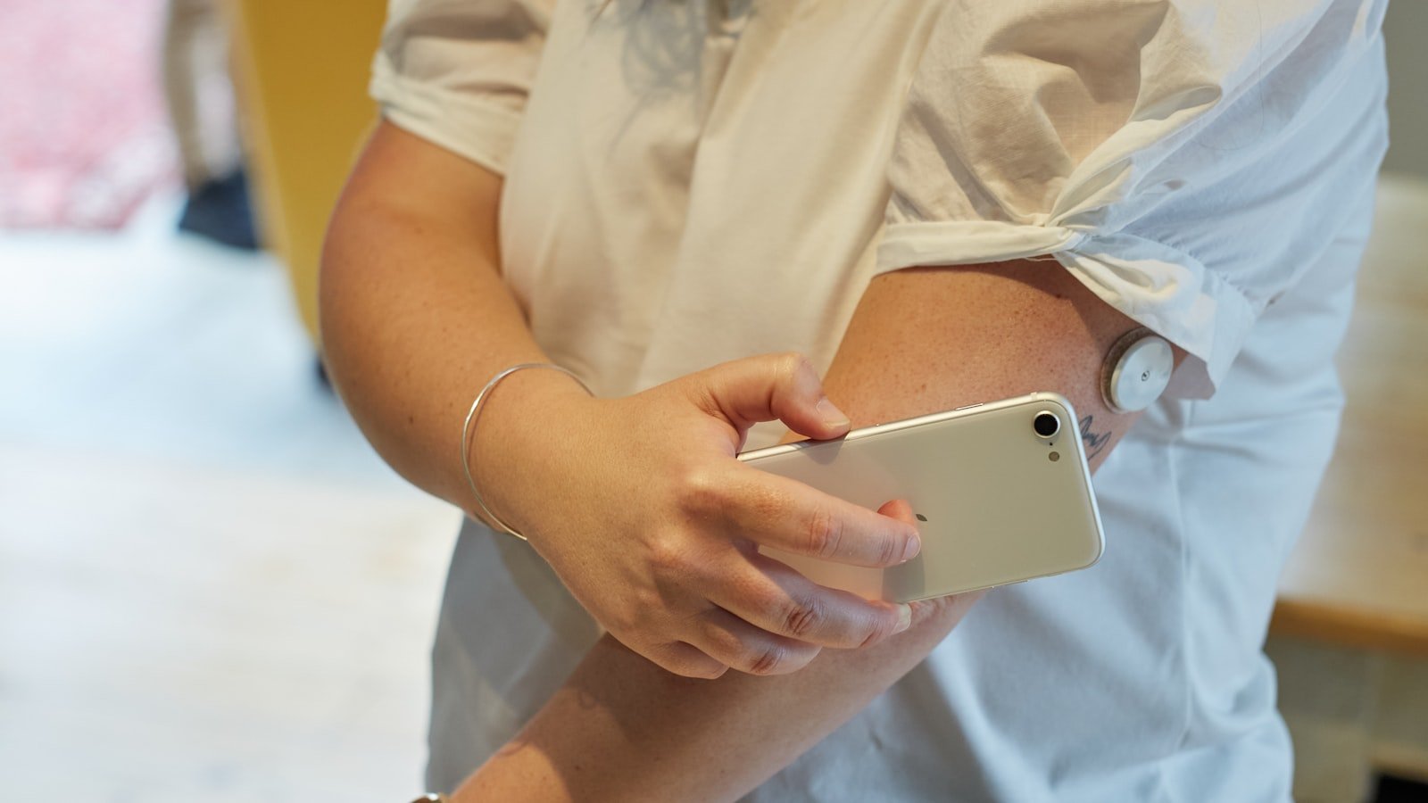 Person scanning a flash glucose monitor on their arm with a smartphone