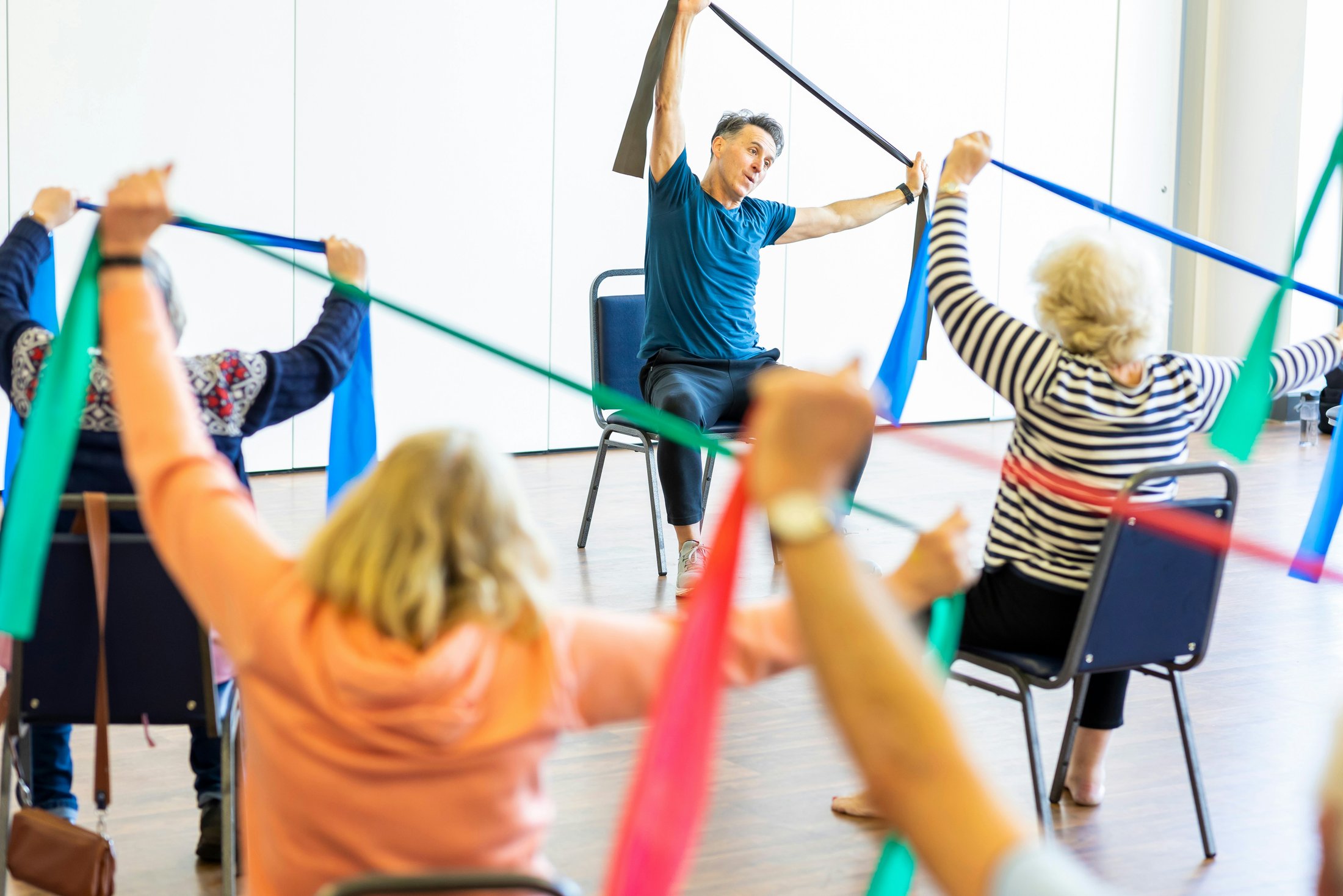 Older adults using resistance bands during a seated group exercise class