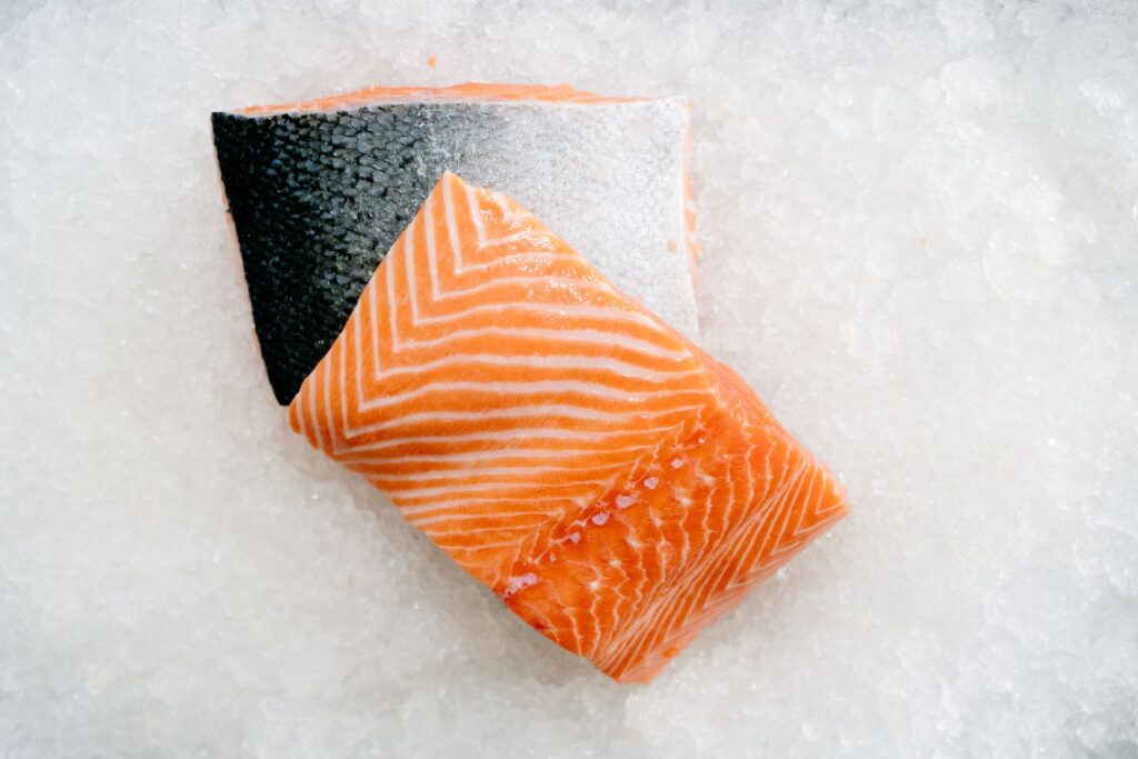 Close-up of a raw salmon fillet on ice, representing dietary EPA and DHA sources