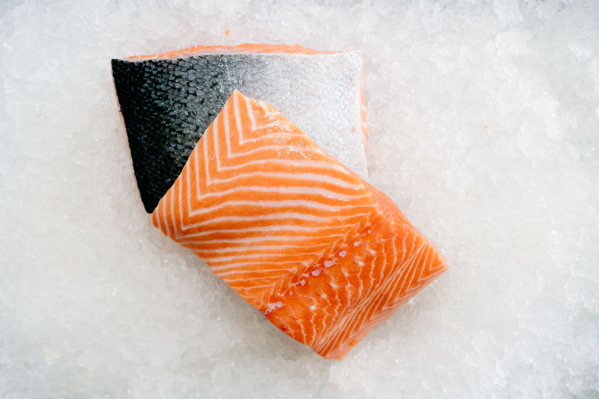 Close-up of a raw salmon fillet on ice, representing dietary EPA and DHA sources
