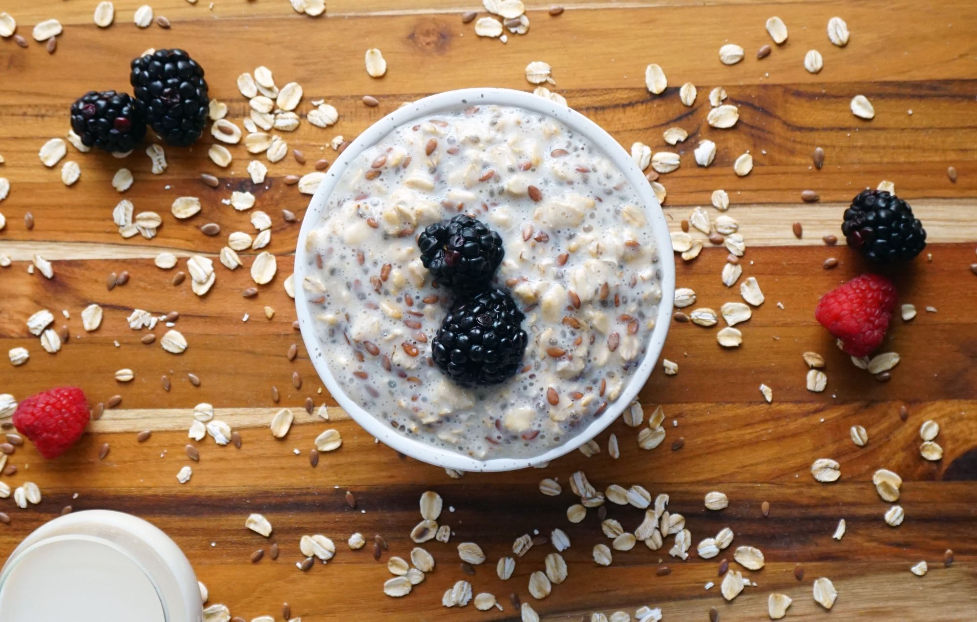 Bowl of oatmeal with berries and seeds on a table