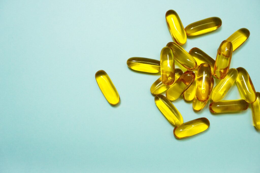 Yellow supplement capsules on a pale blue surface for an article on probiotic supplements