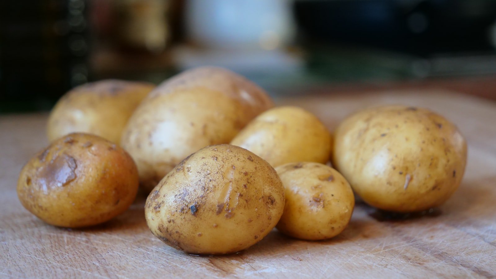 Raw potatoes on a wooden board, representing resistant starch food sources