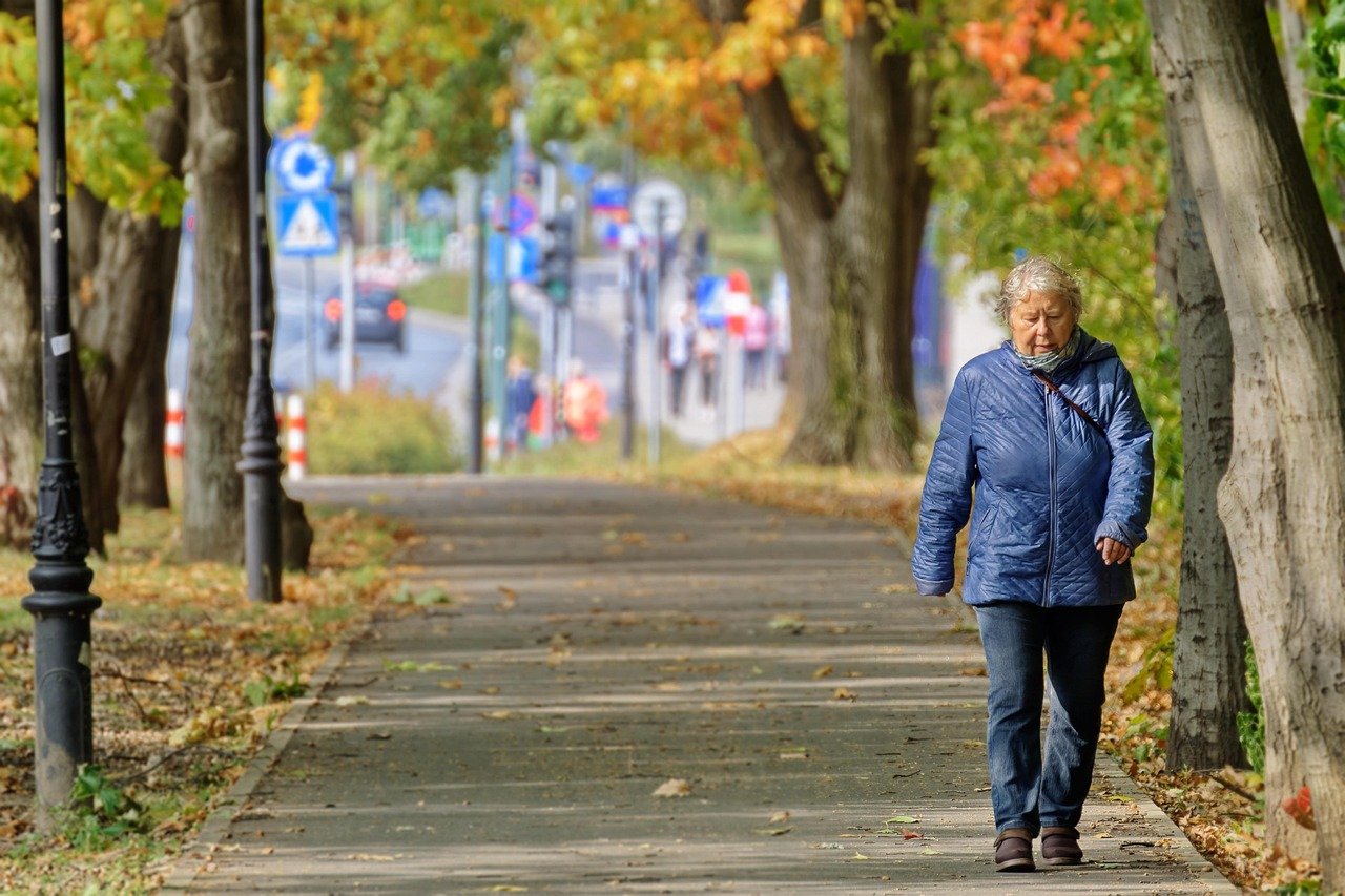 Older woman walking along a park path