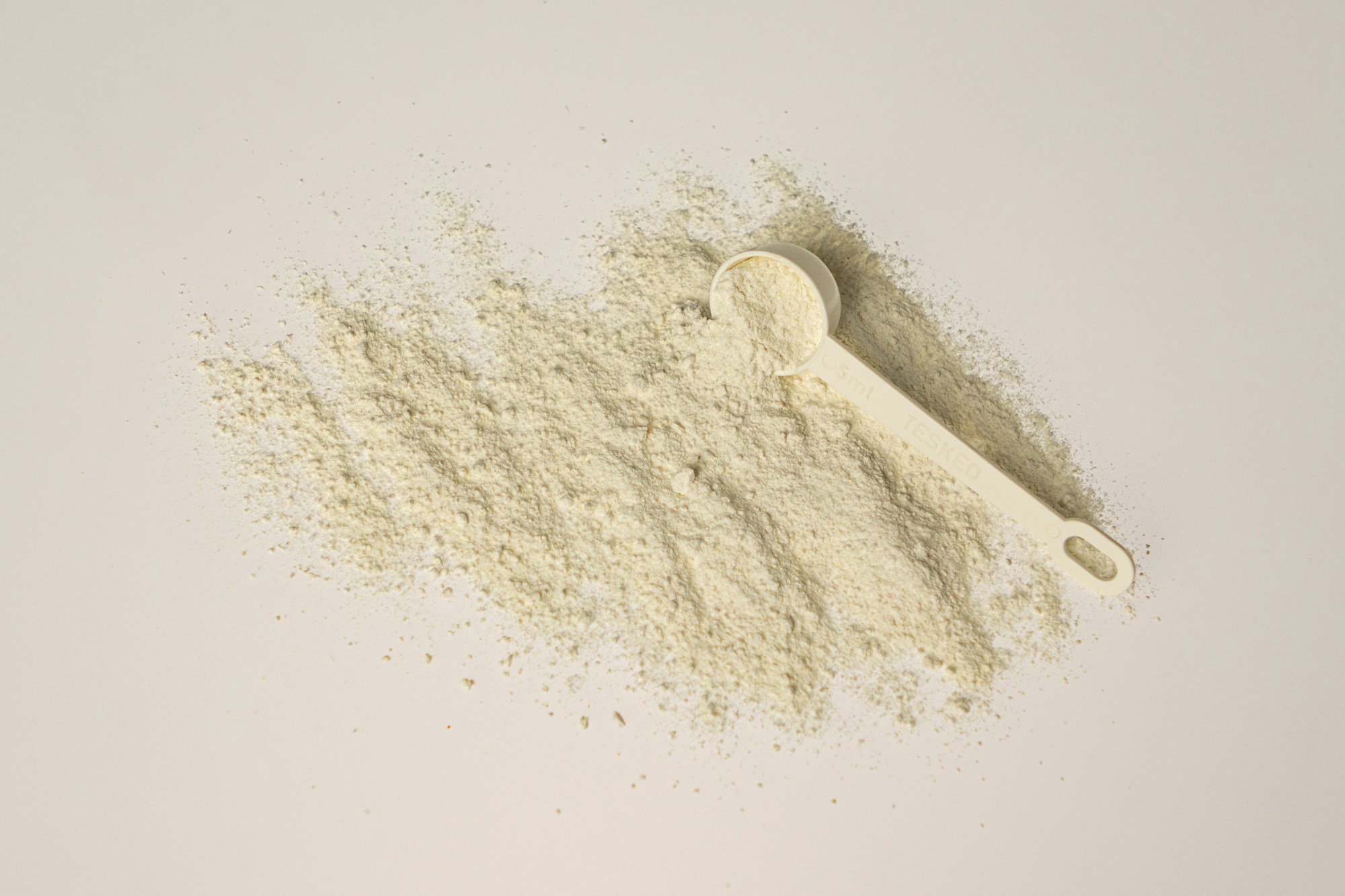 A measuring scoop with pale supplement powder