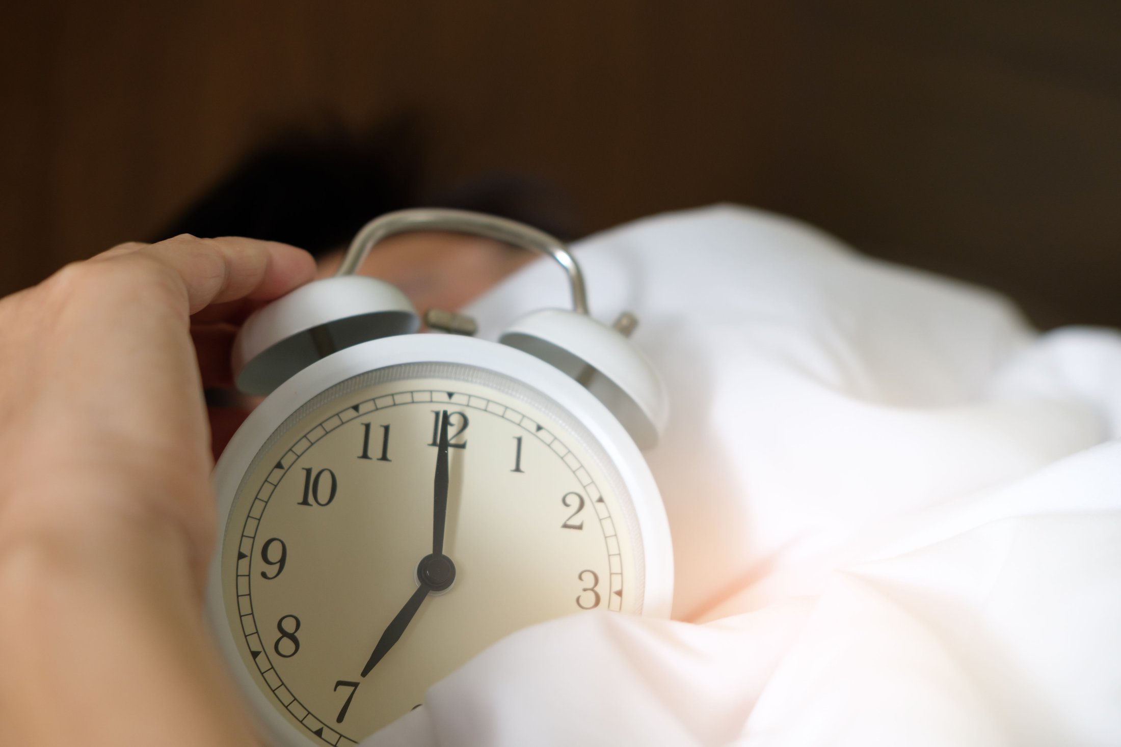 Woman sleeping in bed in soft morning light