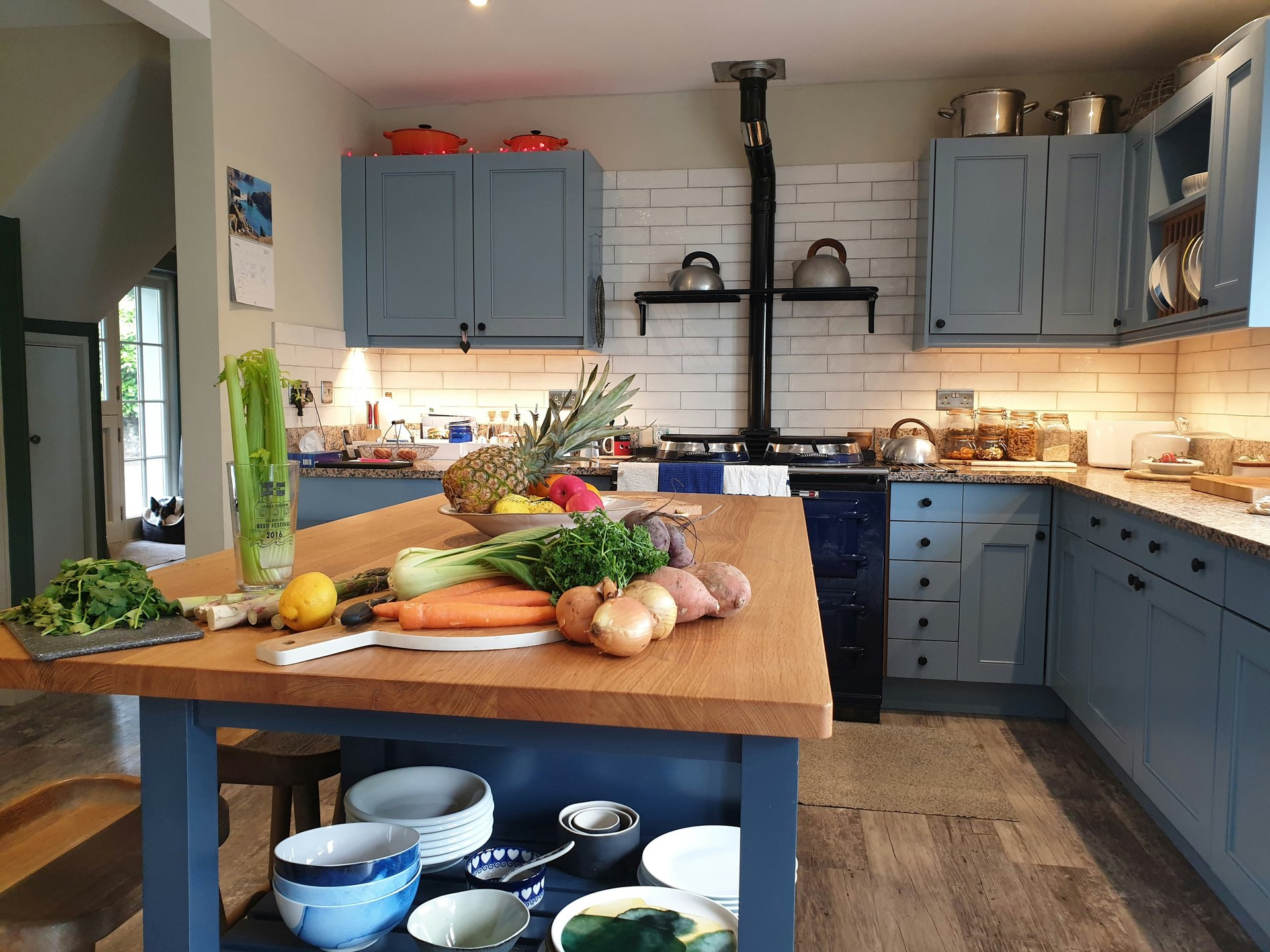 A kitchen with a table full of fresh vegetables