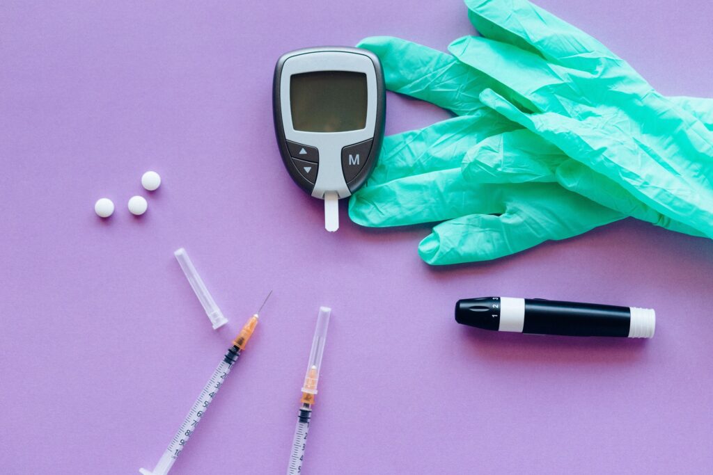 Black and white click pen beside pink textile, representing HbA1c blood testing