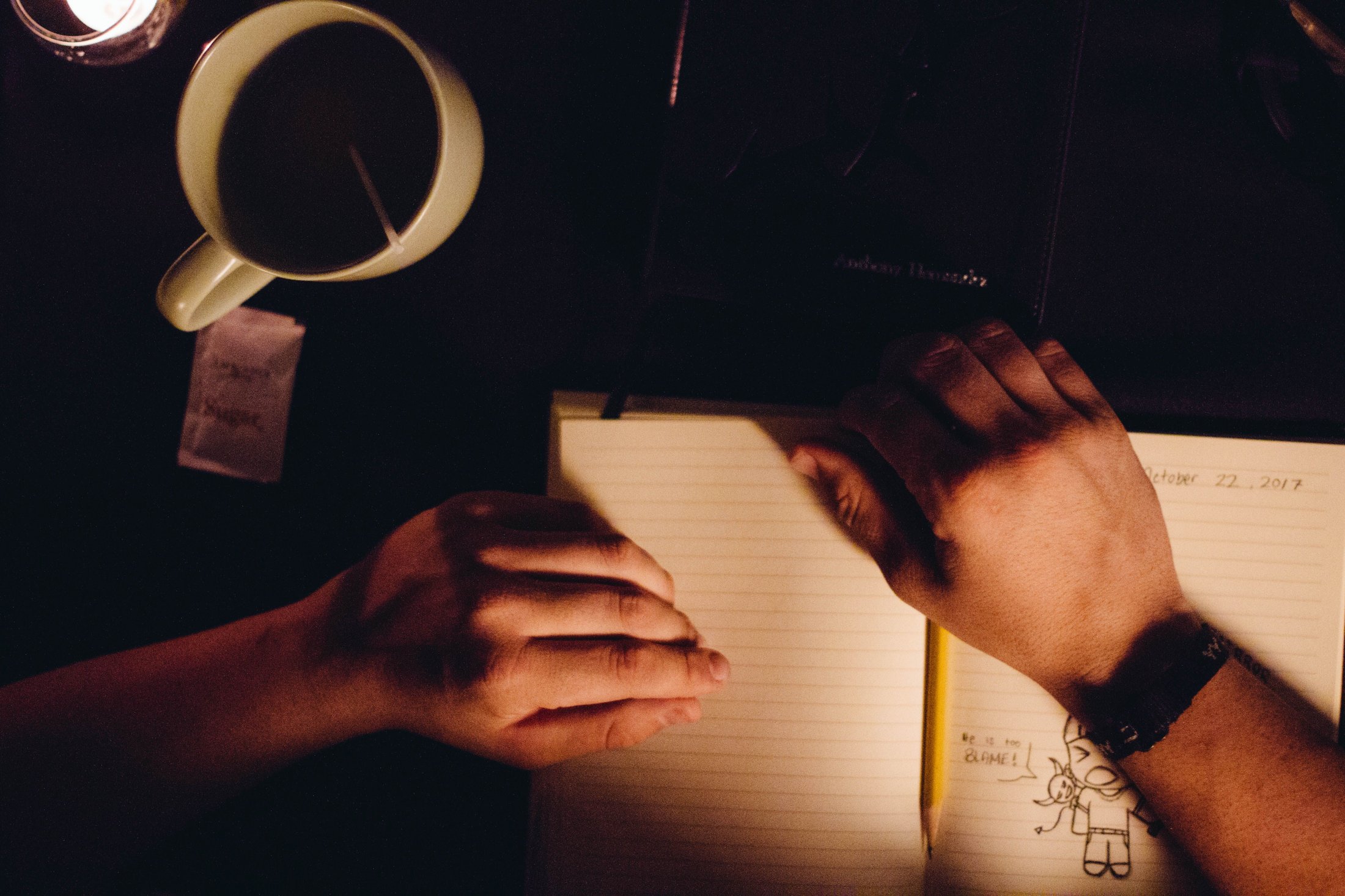 Open notebook and pen beside a cup, illustrating self-compassion practice for stress