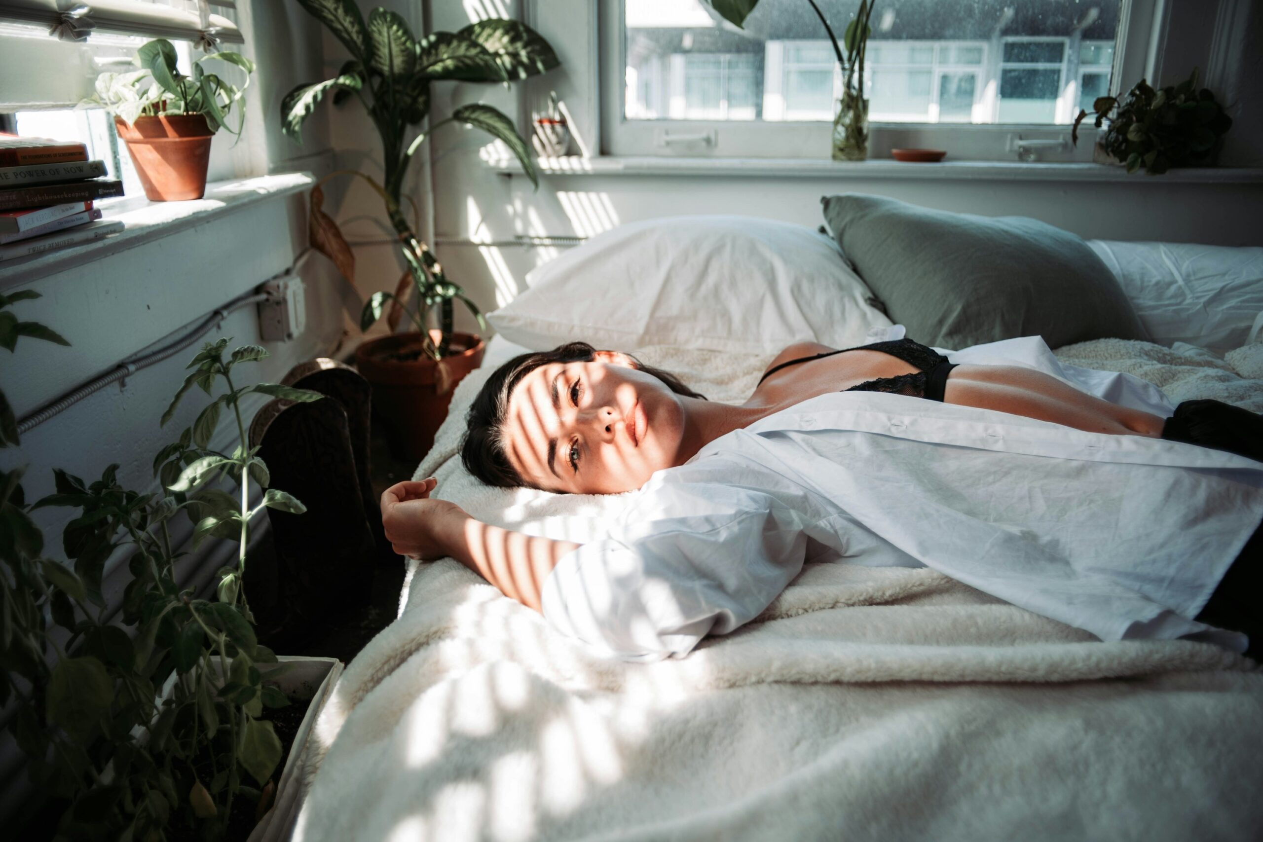 Woman resting in bed in a white robe