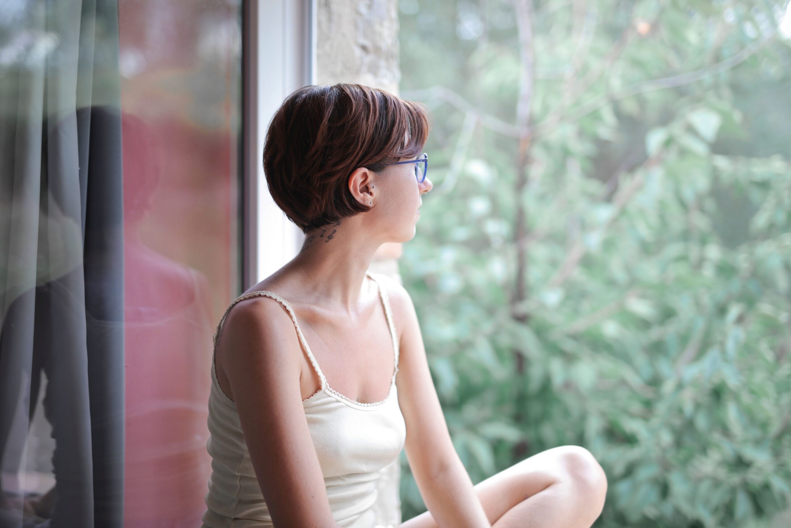 Woman seated by a window in a quiet reflective moment