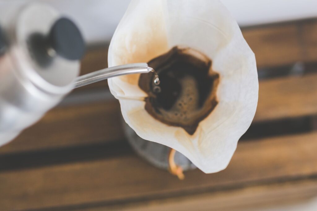 Coffee brewing through a paper filter into a glass carafe