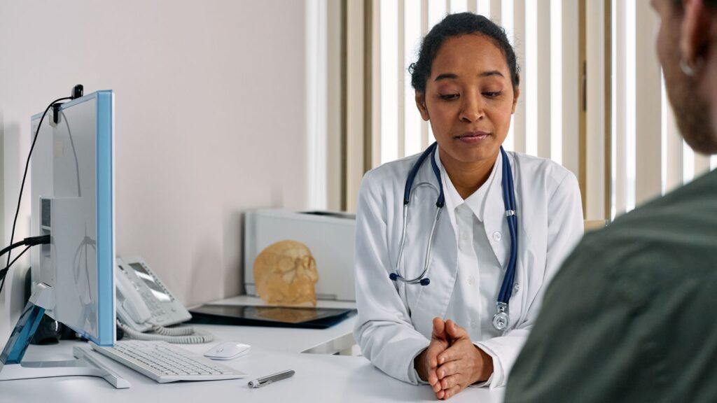 Illustrative consultation between a clinician and another person; models pictured.